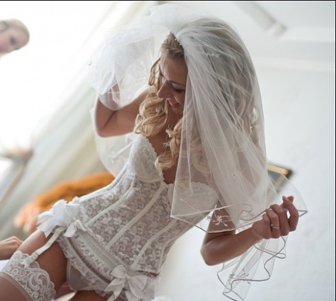 Сексуальная невеста в свадебной фате и белых чулках 